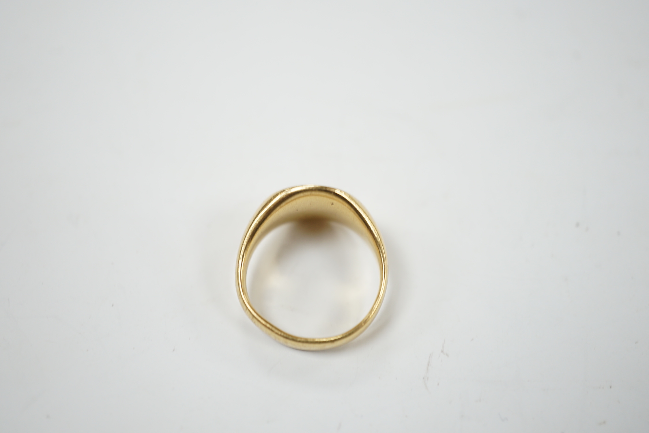A George V 18ct gold signet intaglio ring, carved with family crest and motto, size K, 9 grams.